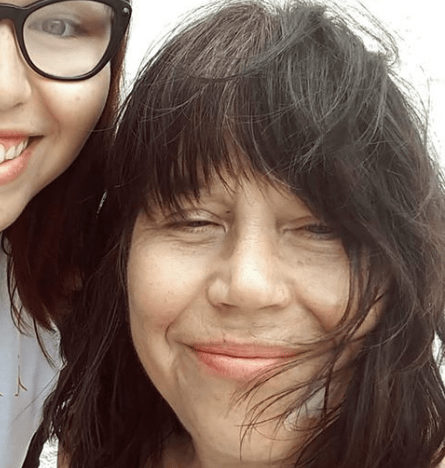 Photo of a smiling woman with brown hair and her daughter